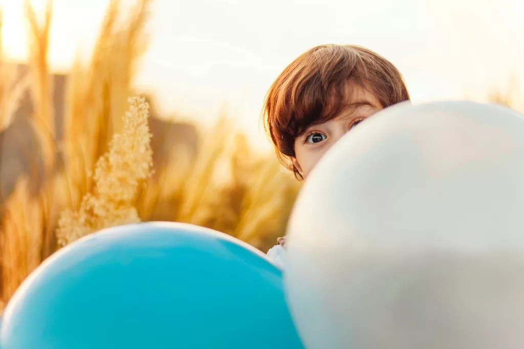 Child behind balloons